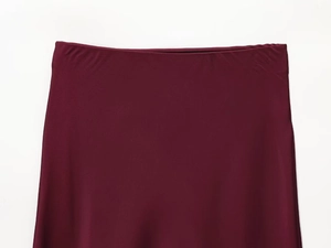 Close-up of wine red satin midi skirt showing smooth high waist and silky texture