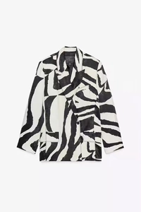Dettaglio di un blazer zebrato con revers a dente e tasche con patta in vista piana