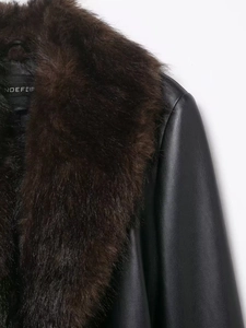 Détail du manteau en similicuir noir avec col amovible en fausse fourrure marron de luxe