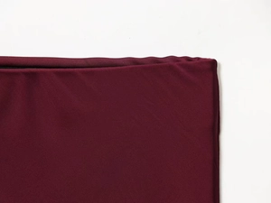 Close-up of wine red satin midi skirt showing detailed stitching and elastic fabric texture