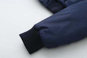 Detail shot of the black ribbed knitted cuffs on a navy blue casual outerwear jacket