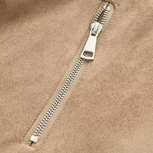 Detail shot of silver metal zipper on premium brown suede moto jacket fabric