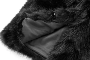Detailed close-up of black faux fur vest featuring a metal hook closure and smooth lining