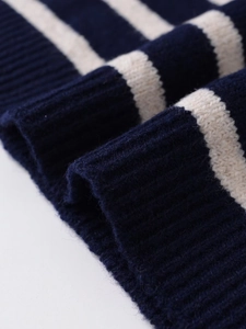 Close-up of navy and cream striped knit sweater showing ribbed cuff texture