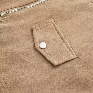 Close-up of brown suede jacket detailing silver metal snaps and a high-quality zipper