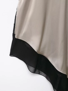 Détail de satin champagne avec patchwork en mousseline noire et bordure en dentelle