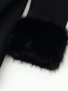 Detail shot showing the dense and fluffy black faux fur collar of a winter wool coat