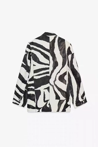 Vista dettagliata del retro di un blazer con stampa zebrata bianca e nera dal taglio ampio