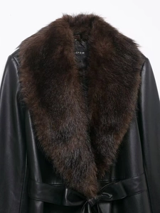 Détail d'un manteau en similicuir noir avec col amovible en fourrure marron et ceinture à la taille