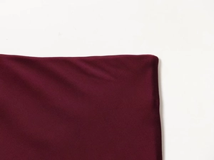Detailed macro view of the premium burgundy satin fabric texture and smooth fine stitching
