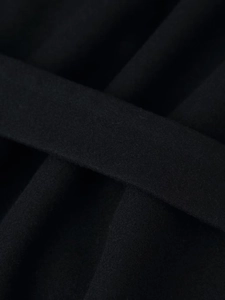 Close-up of black wool coat belt showing high-quality fabric texture and short fleece
