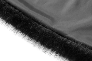 Close-up of black faux fur texture and smooth synthetic fabric seam on a casual vest