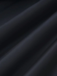 Detailed macro view showing the high-density black fabric texture and soft light on coat