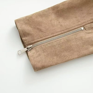 Detailed macro shot of premium silver metal zipper on camel suede biker jacket