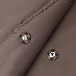 Deep brown quilted jacket with metallic snap buttons and smooth padded synthetic fabric