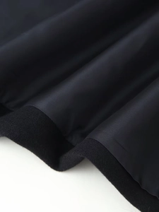 Detailed close-up showing the premium black wool fabric and smooth inner lining of the coat