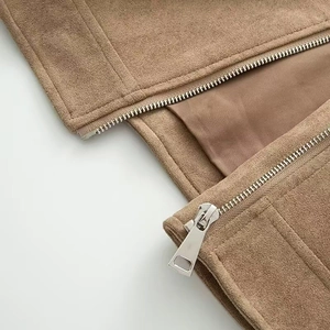Close-up of brown faux suede jacket featuring durable metal zippers and neat stitching