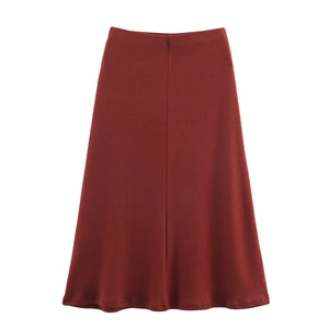 Detail of burgundy ribbed knit midi skirt featuring a central seam and A-line silhouette