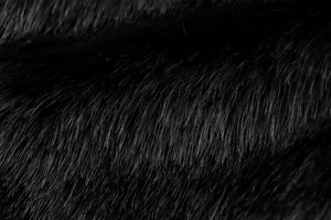 Close-up of soft black faux fox fur texture with a luxurious silky glossy finish
