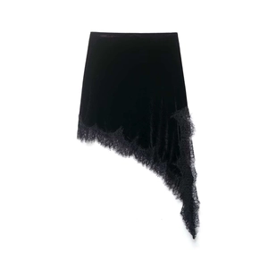 Detailed close-up of asymmetrical black velvet skirt with delicate lace trim edging