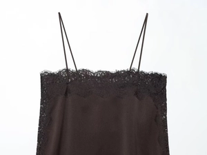 Detail of black silk camisole featuring delicate lace trim and thin shoulder straps