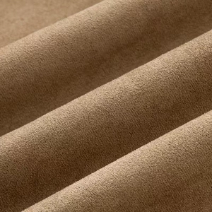 Macro shot of dark brown suede fabric texture with soft ripples on lapel jacket