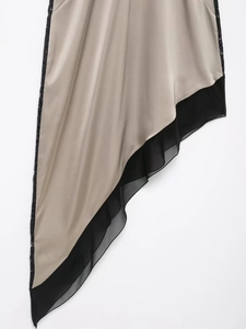 Détail d'une robe asymétrique en satin champagne avec bordure en dentelle noire