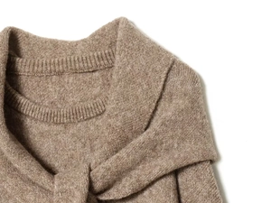 Detail of overlapping crew neck design and fine texture on a coffee knit sweater