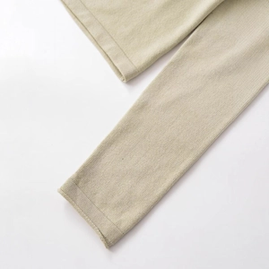 Close-up of beige knitted sweater sleeve cuff with fine ribbed texture and premium finish