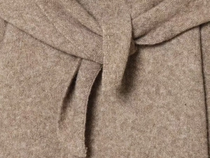 Close-up of elegant knotted waist belt on camel brown knit sweater for winter outfits