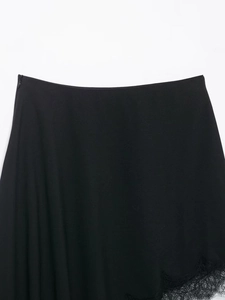 Detail of black satin skirt featuring a side zipper and delicate lace trim hemline