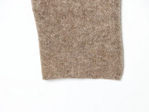 Close-up of oatmeal knit texture and high-quality cuff detail on long-sleeve sweater