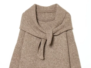 Detailed close-up of light brown knit sweater with unique scarf-tied collar design