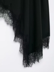 Detail shot of the black satin skirt featuring intricate eyelash lace trim and floral patterns