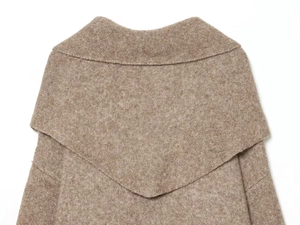 Close-up of oatmeal brown knit sweater showing soft wool texture and oversized collar