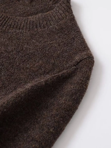 Detailed close-up of dark brown knit cardigan showing crew neck and soft wool texture