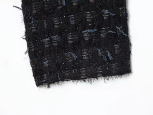 Macro detail of black tweed fabric with blue threads and metallic silver shimmer