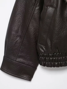 Détail de veste en similicuir marron foncé avec ourlet élastique et col en fourrure amovible