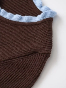 Detailed macro view of high-quality brown knit fabric with blue ruffle collar trim
