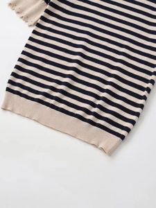 Detail of nautical navy and beige striped knit top with delicate hollow wave cuffs