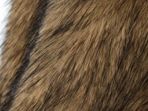 Macro shot of faux fur texture showing soft brown and black long hair fibers with shine