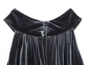 Detail shot of black velvet neckline with bow accent and ruched fabric texture