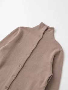Detail of minimalist taupe turtleneck knit cardigan with matching single-breasted buttons