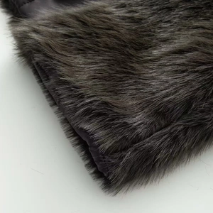 Close-up detail of dark grey faux fur coat showing long plush texture and purple lining