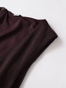 Detailed close-up of dark burgundy dress zipper and size S label on fabric waistband