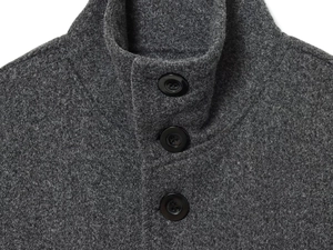 Detail shot of the stand collar and black buttons on a dark grey wool blend cape coat
