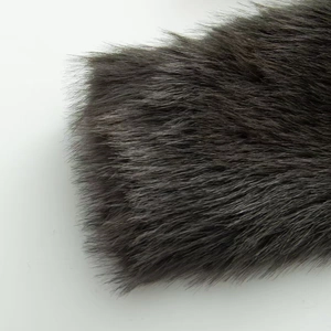 Detailed macro view of deep charcoal faux fur texture with thick plush fibers and soft gloss