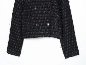Detail of black tweed jacket featuring silver metallic threads and fringe cuff edges