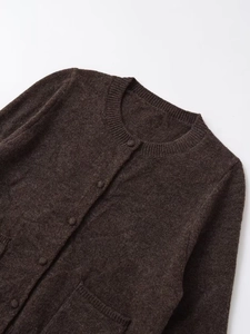 Close-up of dark brown knit cardigan with ribbed crew neck and matching buttons