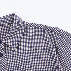 Detail shot of blue and white plaid shirt with seersucker texture and navy buttons